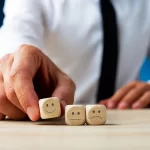 man holding a cube with a smiley face on it