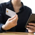 woman holding her phone and credit card