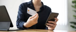 woman holding her phone and credit card
