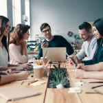 group of people talking with each other at a table
