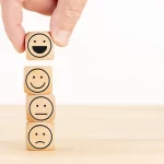 wooden cubes with different expressions stacked on top of each other