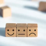 three wooded cubes lined up with different expression on them