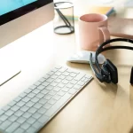 paid of headsets sitting on desk with Keyboard and mouse