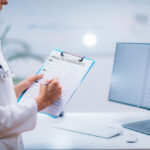 doctor filling out a health insurance form